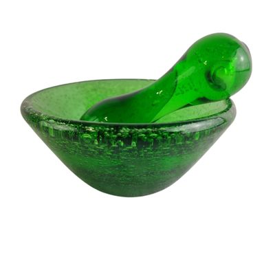 un bol en verre vert dans lequel se trouve une cuillère verte