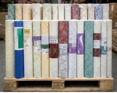 many rolls of fabric on a pallet in a warehouse