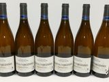 six bouteilles de vin sont alignées sur une table