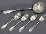 six cuillères en argent et une cuillère sur laquelle est gravé un visage