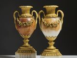 une paire de vases dorés et blancs posés sur une table blanche