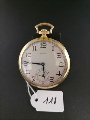 a gold pocket watch on a black surface with a price tag