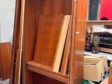 une armoire en bois dont la porte est ouverte, dans une pièce