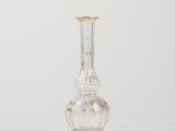 a glass vase with a gold rim sitting on a white surface