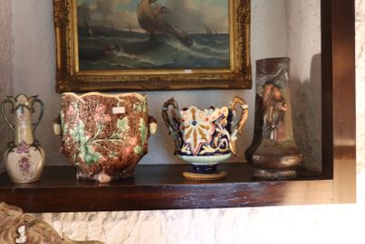 many vases sitting on a shelf with a painting in the background