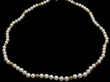 un collier de perles blanches avec un fermoir en or