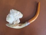 a picture of a pipe with a carved head on it