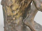 bronze statue of a boy sitting on a tree stump holding a book