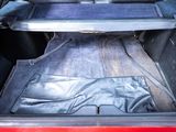 a red car with its trunk open and a blanket in the trunk