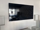 une photo d'une télévision à écran plat montée sur un mur