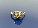 un gros plan d'une bague sertie d'un diamant jaune sur un fond bleu