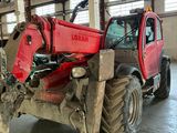 a red tractor that is parked inside of a building
