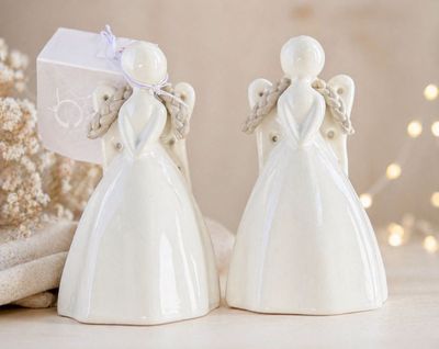 deux figurines d'anges posées sur une table avec un cadeau