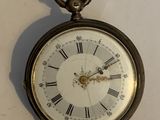une horloge accrochée au mur avec des chiffres romains
