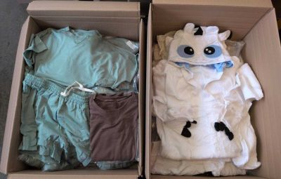 deux cartons contenant des vêtements, posés par terre