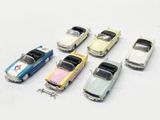 several toy cars are lined up in a row on a white surface