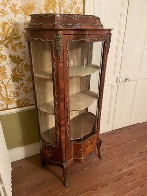une armoire d'angle placée dans un coin de la pièce