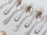 a lot of silver spoons and spoons on the table