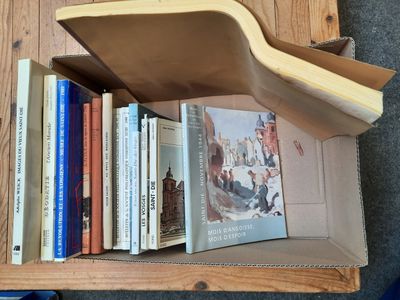 une boîte en carton posée sur une table, avec des livres dessus