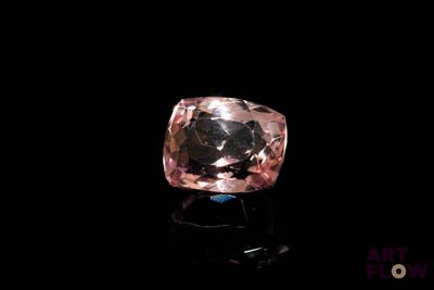 un diamant rose sur une surface noire, avec un fond noir