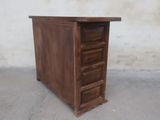 a small wooden chest of drawers on a concrete floor