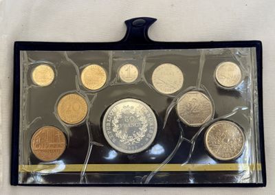 un assortiment de pièces de monnaie dans un étui en plastique posé sur une surface blanche