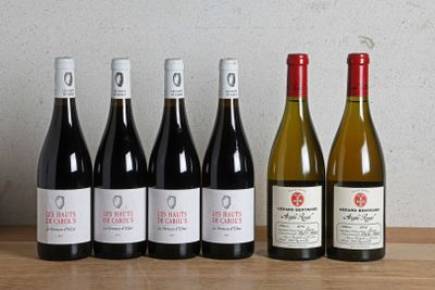 six bottles of wine are lined up on a wooden table