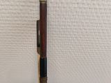 an old wooden pipe with a metal handle on a white surface