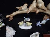 many figurines of birds sitting on a tree branch