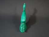 a green glass bottle with a green handle on a table