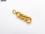 a close up of a gold plated chain link on a white surface