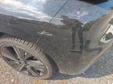 a reflection of a man on the side of a black car