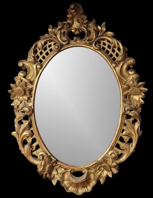 un miroir orné d'un cadre doré sur fond noir
