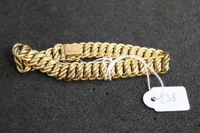 gros plan d'un bracelet en chaîne en or avec une étiquette de prix