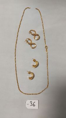 un collier et des boucles d'oreilles en or sont présentés sur un fond blanc