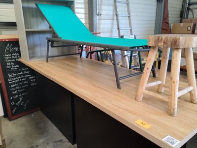 une table sur laquelle se trouve une chaise, devant un tableau noir