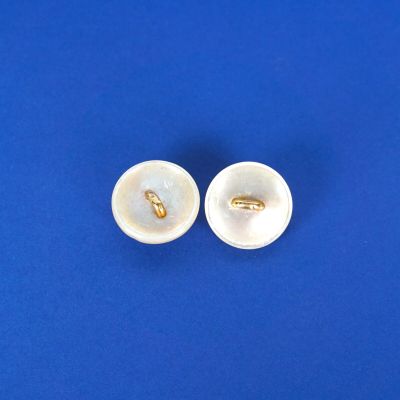 une paire de boutons blancs sur un fond bleu, entourés d'un anneau doré