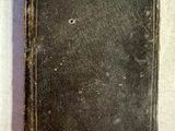 un vieux livre posé sur une table recouverte d'un tissu blanc