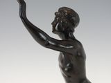 an antique bronze statue of a young boy holding a ball