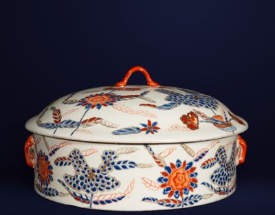 a white and orange bowl with a lid on a blue background