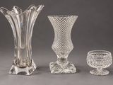 three glass vases and a glass goblet on a table