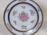an image of a white plate with a blue border and a pink rose on it