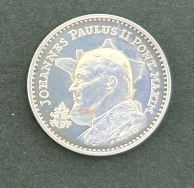 un gros plan d'une pièce d'argent sur laquelle figure l'effigie d'un homme