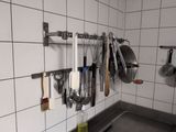 a kitchen with a lot of utensils hanging on the wall