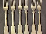 six forks are lined up in a row on a table