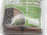 un pot en plastique contenant une plante, posé sur une surface blanche