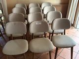 a lot of chairs in a room with a painting on the wall