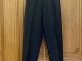 le pantalon est suspendu à un cintre devant une porte en bois