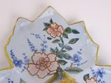 two plates with flowers on them sitting on a table
