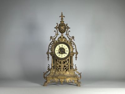 une horloge en or posée sur une table blanche